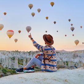 Man traveler vacations beautiful destination in Goreme, Turkey. Fabulous Kapadokya with flying air balloons at sunrise, Anatolia Man traveler vacations beautiful destination in Goreme, Turkey. Fabulous Kapadokya with flying air balloons at sunrise, Anatolia
