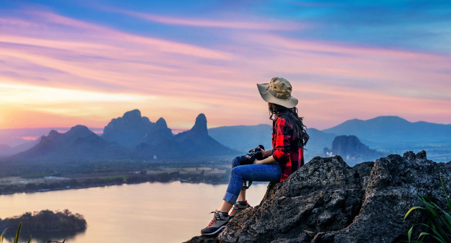 Tourist sitting on Phu sub lek viewpoint at sunset, Lopburi, Tha Tourist sitting on Phu sub lek viewpoint at sunset, Lopburi, Thailand.